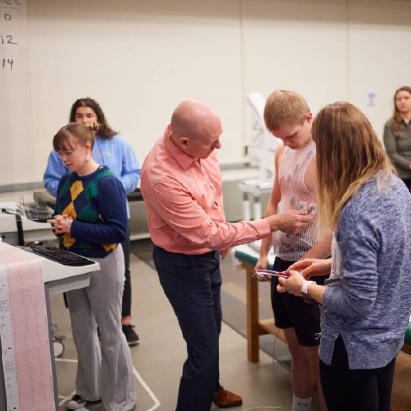 Professor working with students in cardiac rehabilitation class.